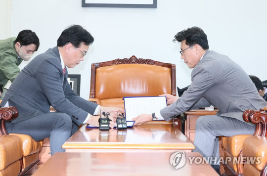 송언석 국민의힘 원내수석부대표와 진성준 더불어민주당 원내수석부대표가 25일 오후 국회 운영위원장실에서 1~2월 임시회 의사일정 합의문에 서명하고 있다.<연합뉴스>